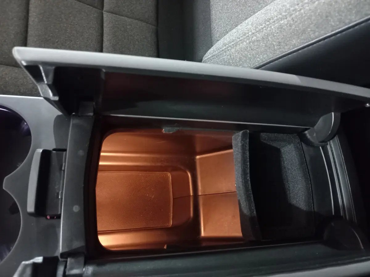 Vue plongeante sur le rangement central ouvert du Citroën C5 Aircross blanc, montrant un compartiment intérieur spacieux.