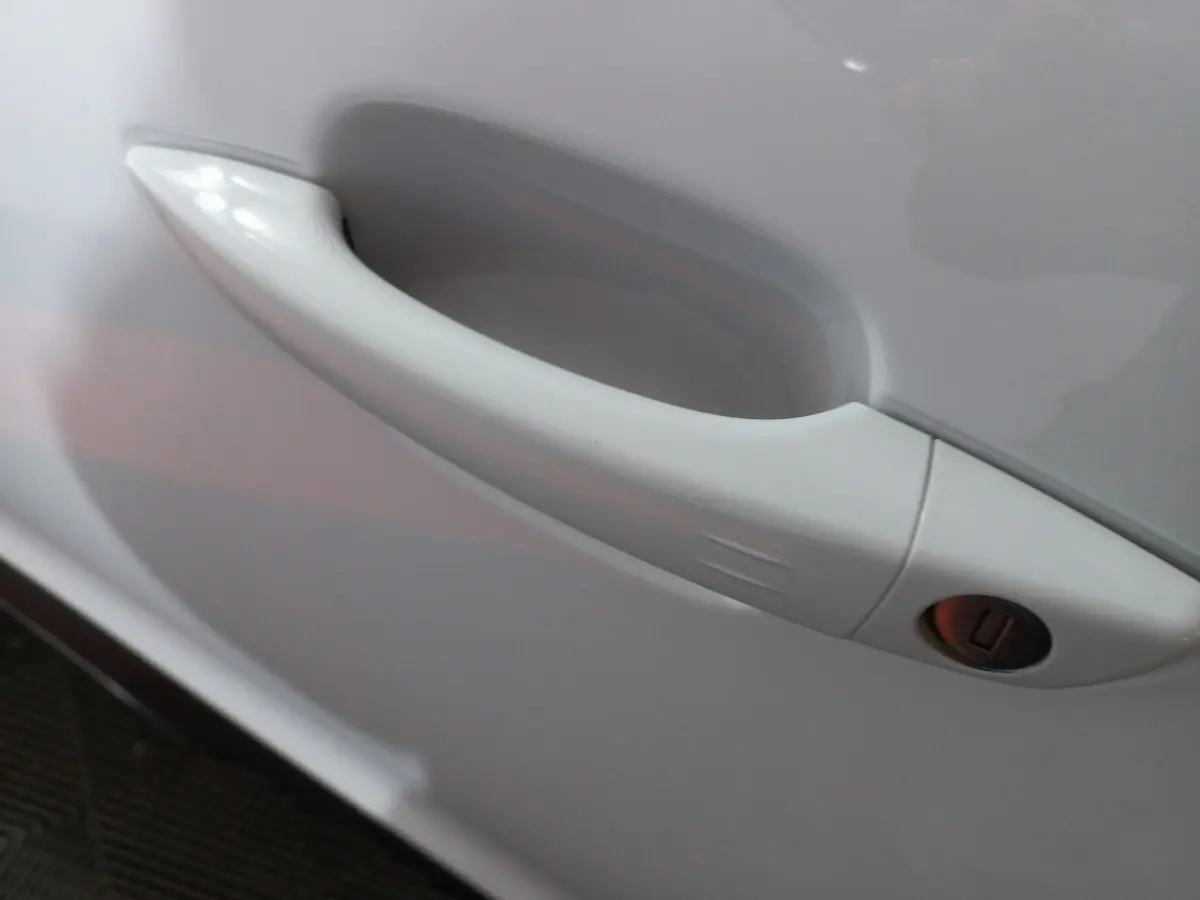 Poignée de porte blanche en gros plan sur le côté gauche d'une Citroën C5 Aircross 2020 finition Feel.