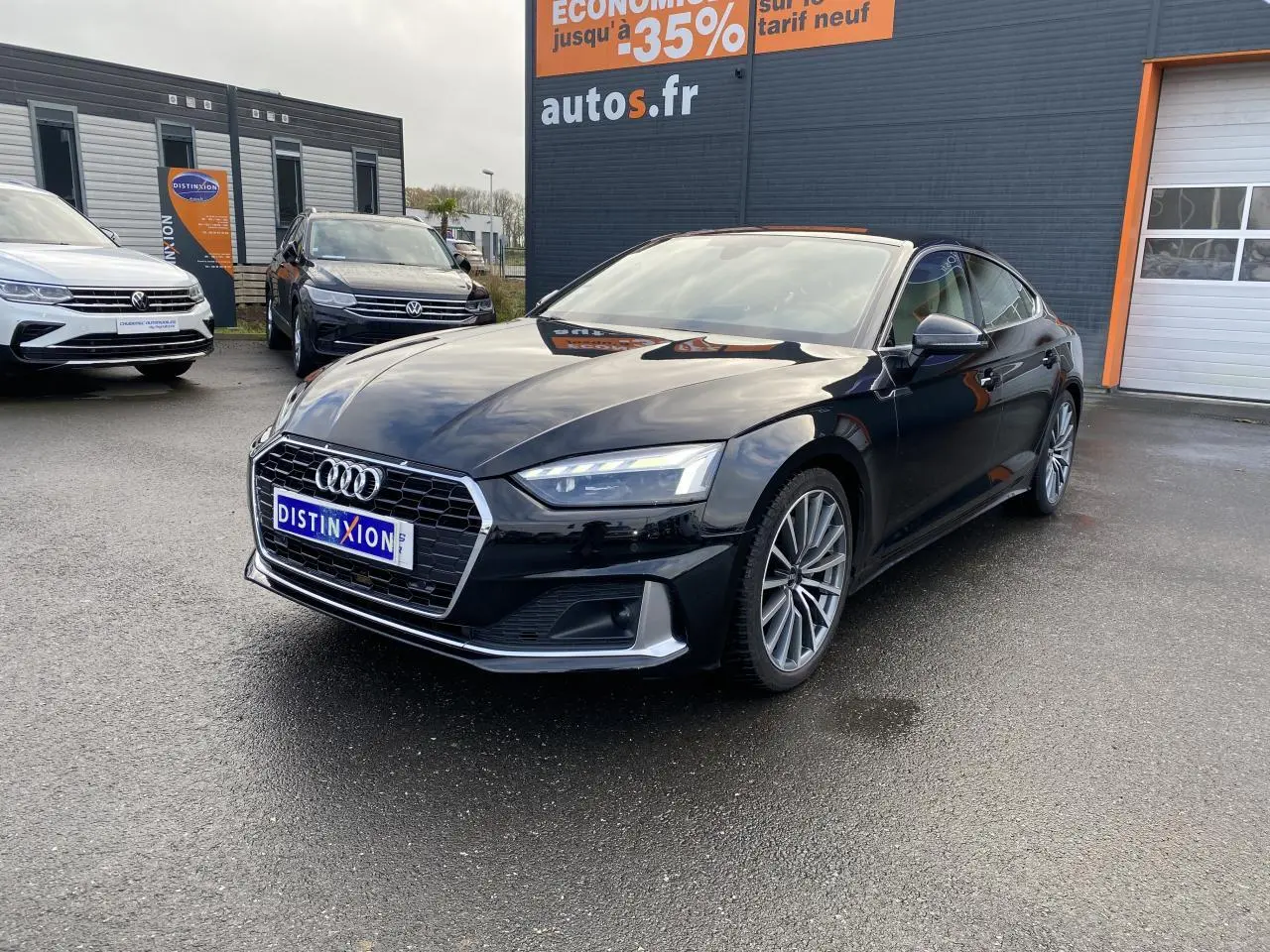 Audi A5 Sportback noir mythic métallisé vue 3/4 avant droit avec jantes multibranches grises contrastées.