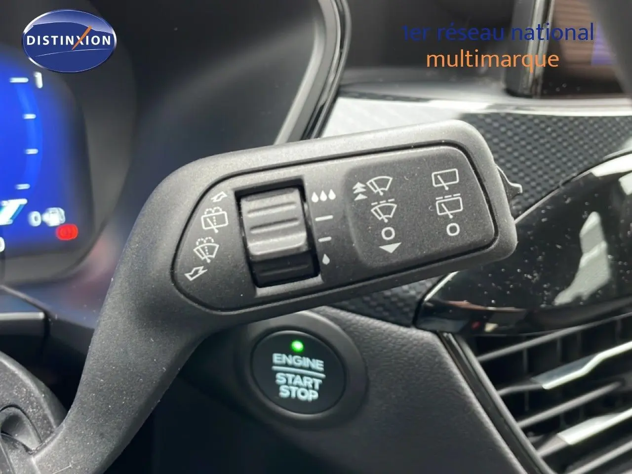 Gros plan sur la commande d’essuie-glace et le bouton start/stop dans l’habitacle du Ford Kuga bleu Vapor Metal 2024.