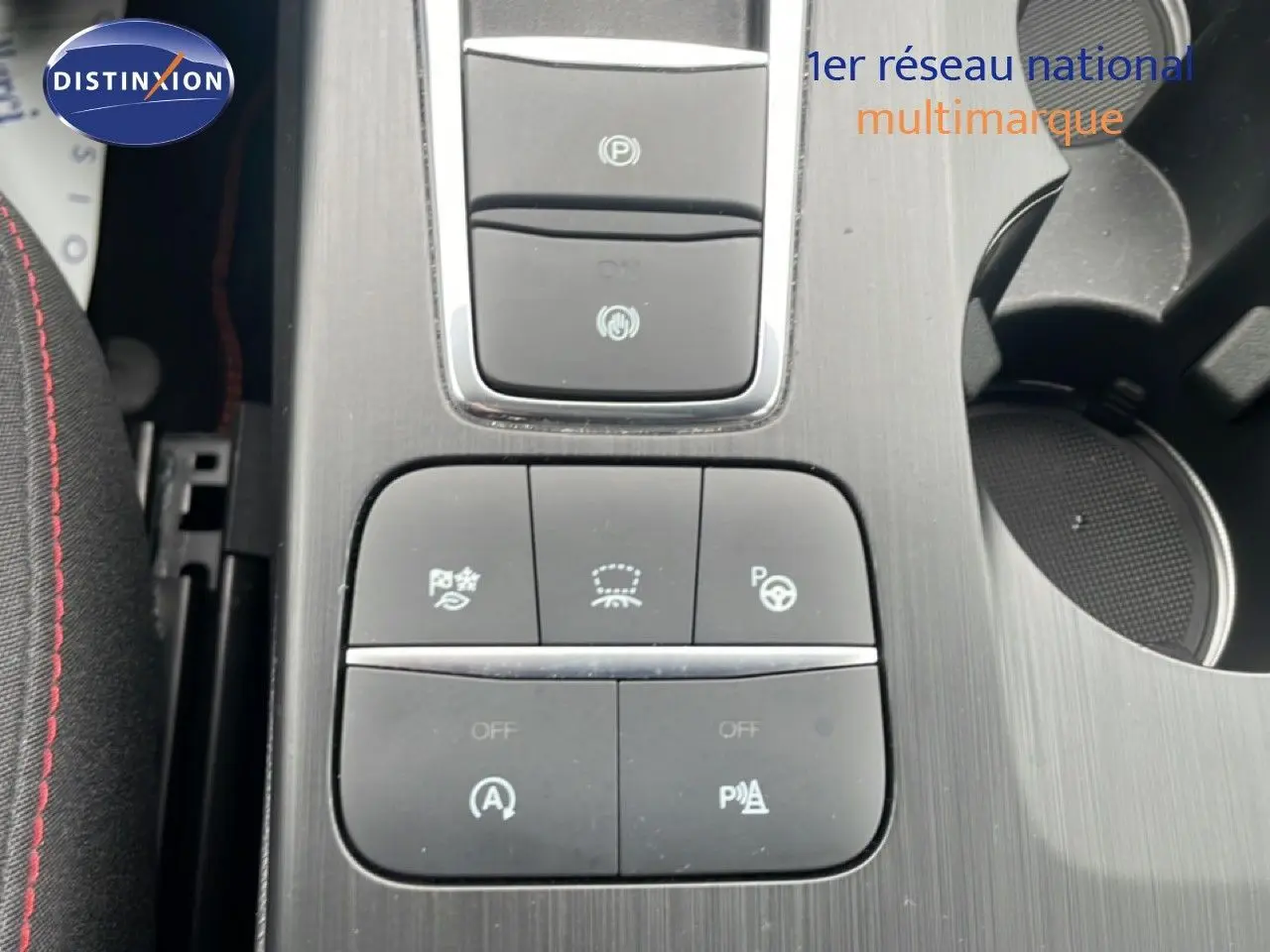 Gros plan sur la console centrale du Ford Kuga 2024, boutons de contrôle d’aide à la conduite et frein électronique.