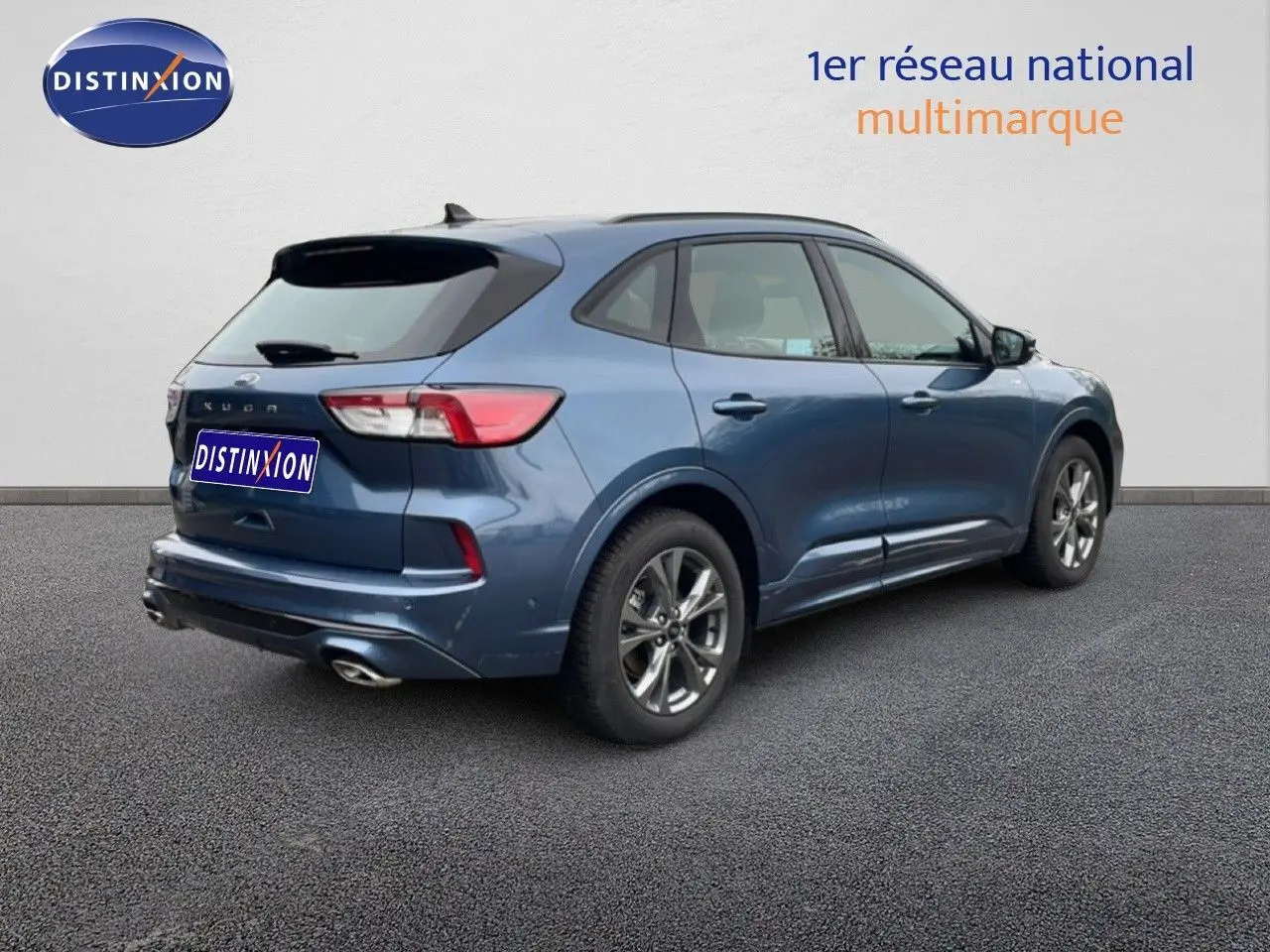 Ford Kuga 2024 bleu Vapor Metal en 3/4 arrière droit, finition ST-LINE avec jantes alliage et double sortie d’échappement.