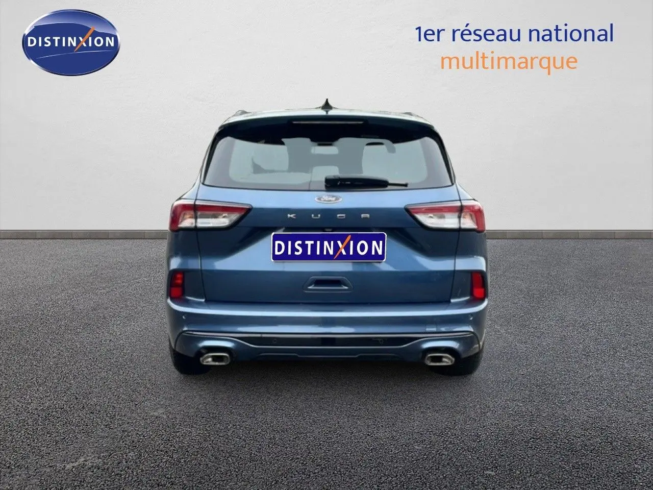 Vue arrière d'un Ford Kuga bleu vapor metal 2024 avec double sortie d'échappement et logo distinctif visible.