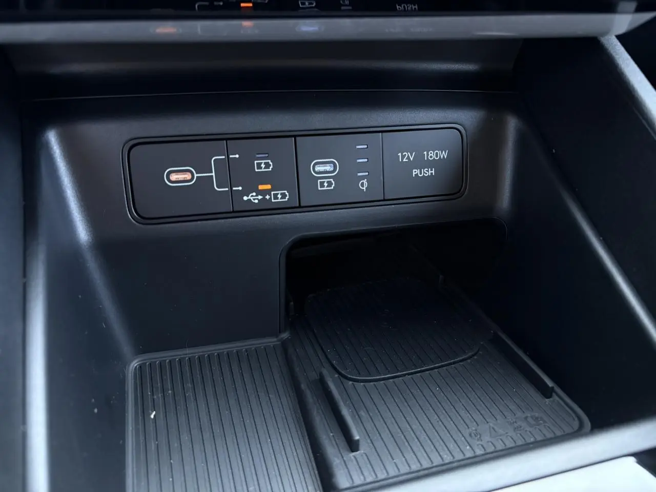 Gros plan sur la console centrale du Hyundai Tucson 2025 en Ecotronic Gray, montrant ports USB et prise 12V.