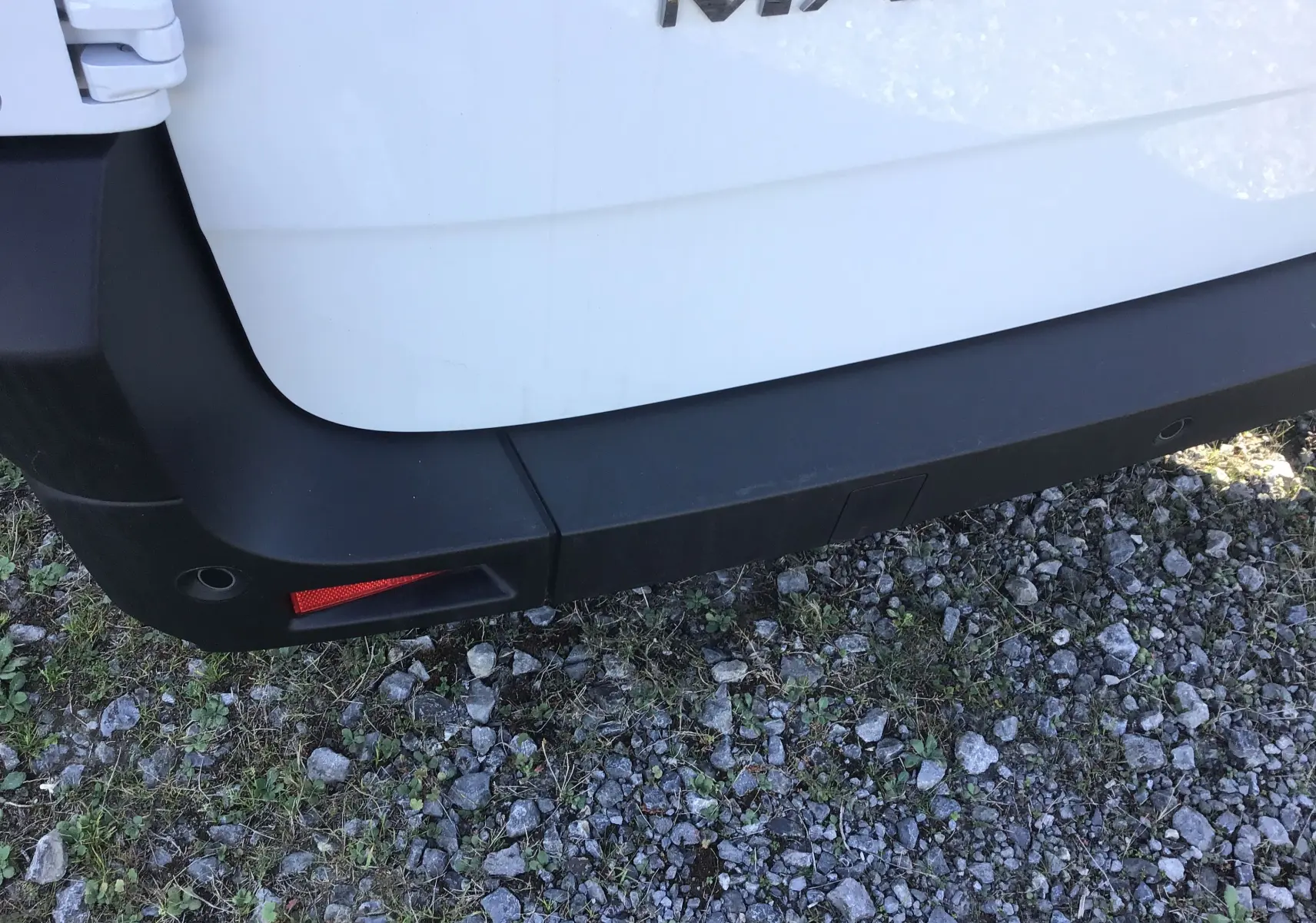 Gros plan sur le pare-chocs arrière gauche blanc du Renault Master L3H2 2025 avec le logo Master visible en haut.
