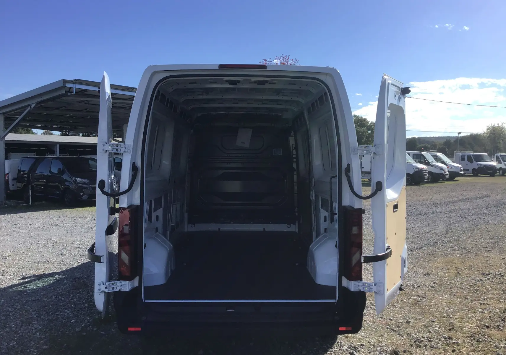 Vue arrière d'un Renault Master blanc L3H2 2025 avec portes ouvertes dévoilant l'espace de chargement vide.
