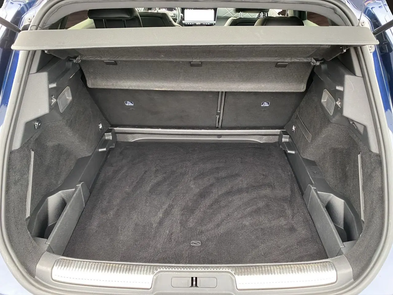 Coffre ouvert vu de l'arrière du DS7 Bleu Eclipse 2024, montrant un espace de chargement propre et bien agencé.