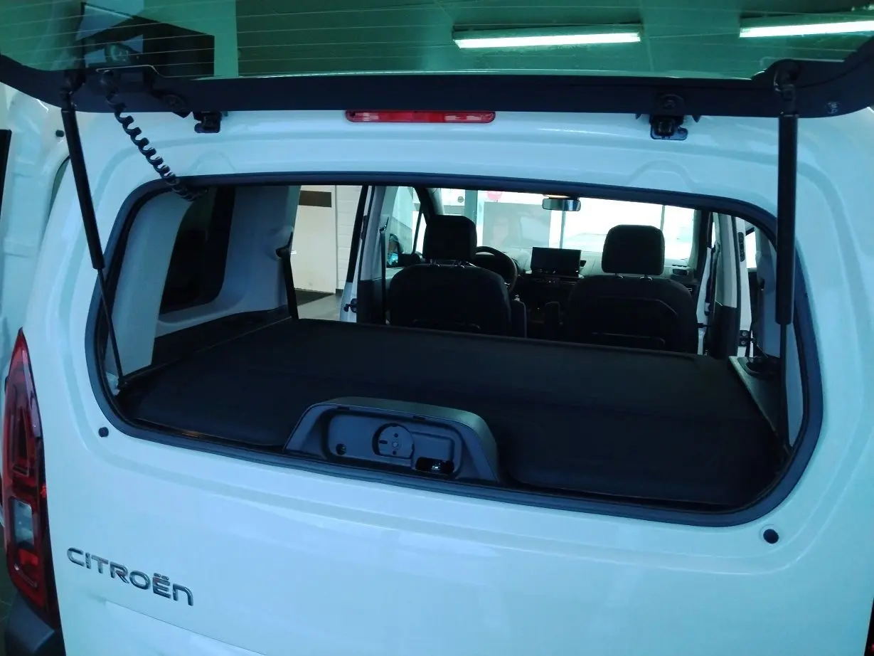 Vue arrière ouverte du Citroën Berlingo blanc 2025, montrant l'intérieur et la cloison de séparation amovible.