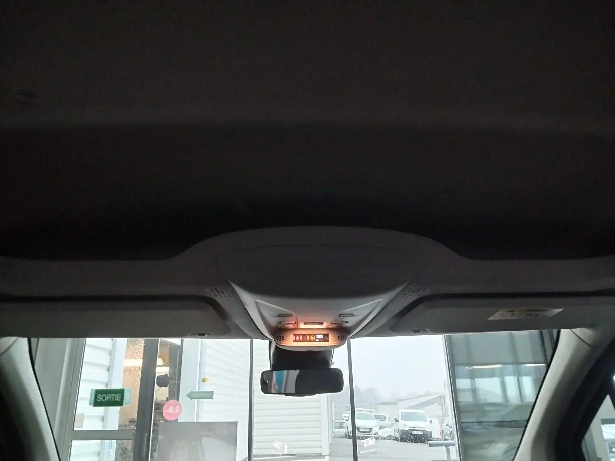 Vue intérieure avant du Citroën Berlingo blanc 2025, montrant le plafonnier et le rétroviseur central allumé.