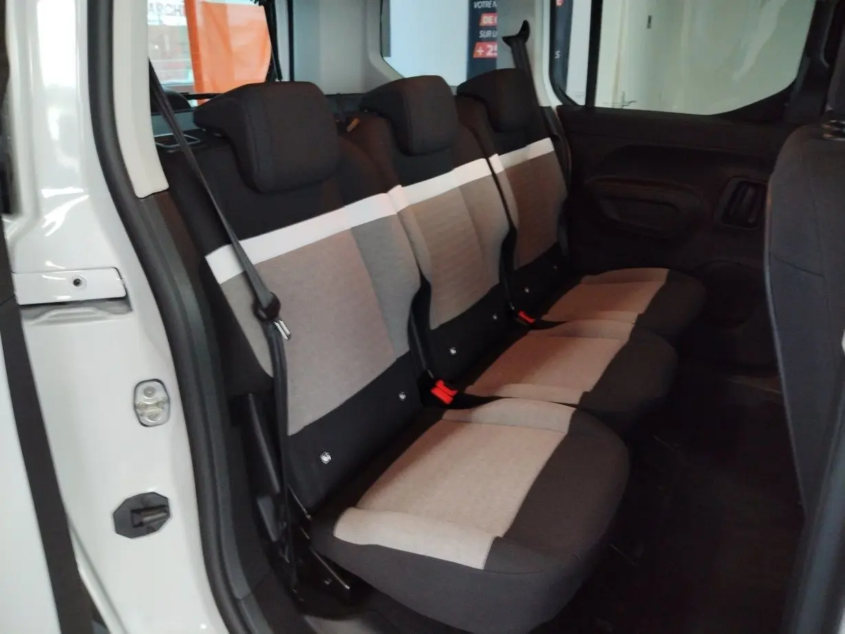 Vue intérieure côté droit sur les trois sièges individuels arrière gris et noir du Citroën Berlingo blanc 2025.