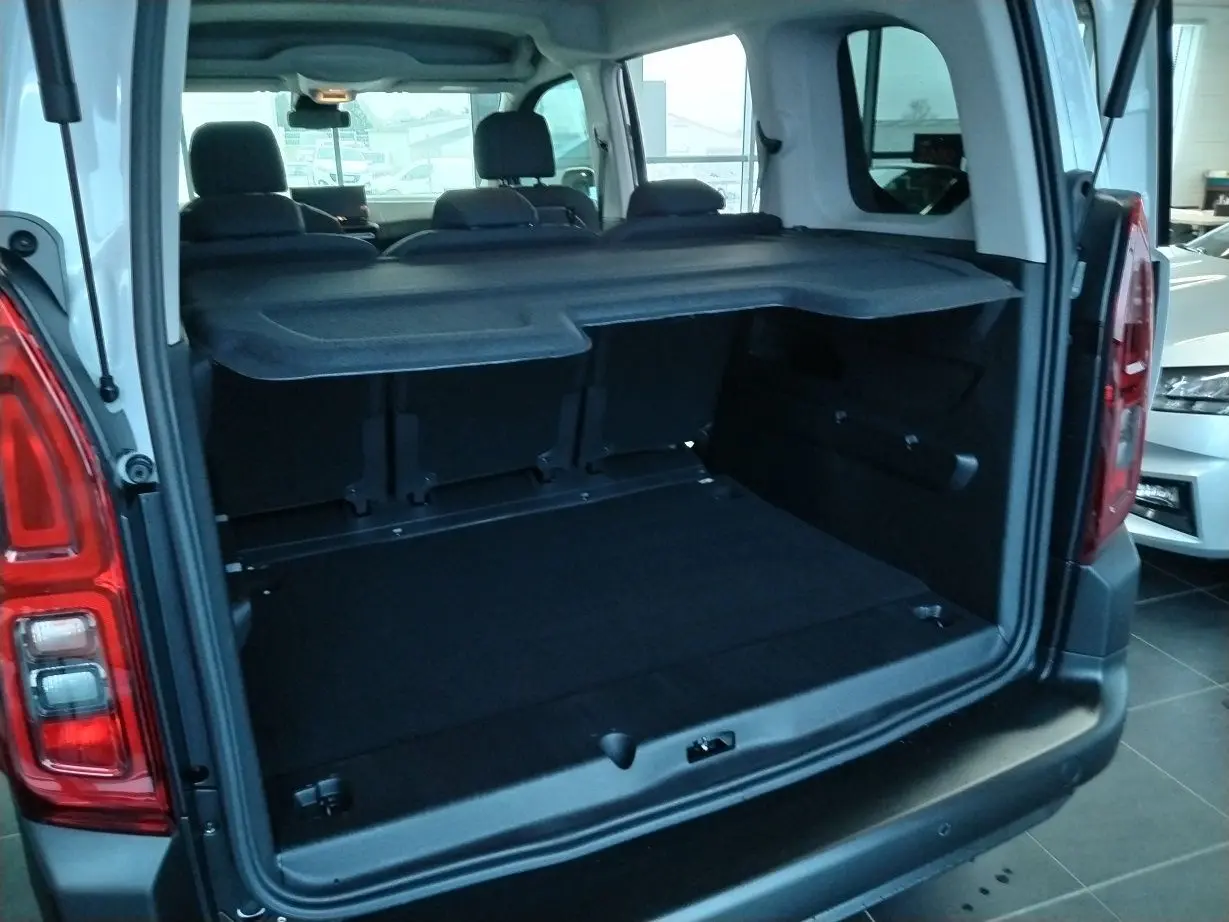 Vue arrière du coffre ouvert du Citroën Berlingo blanc 2025, montrant l’espace de chargement et la tablette cache-bagages.