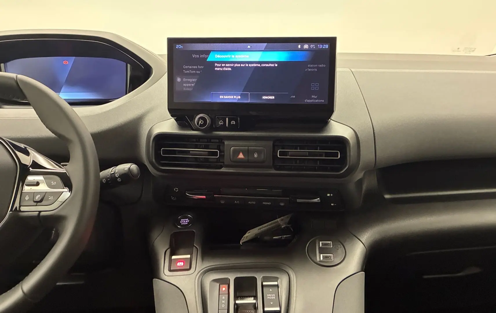 Vue intérieure du tableau de bord du Peugeot Rifter avec écran tactile central et volant multifonction noir.