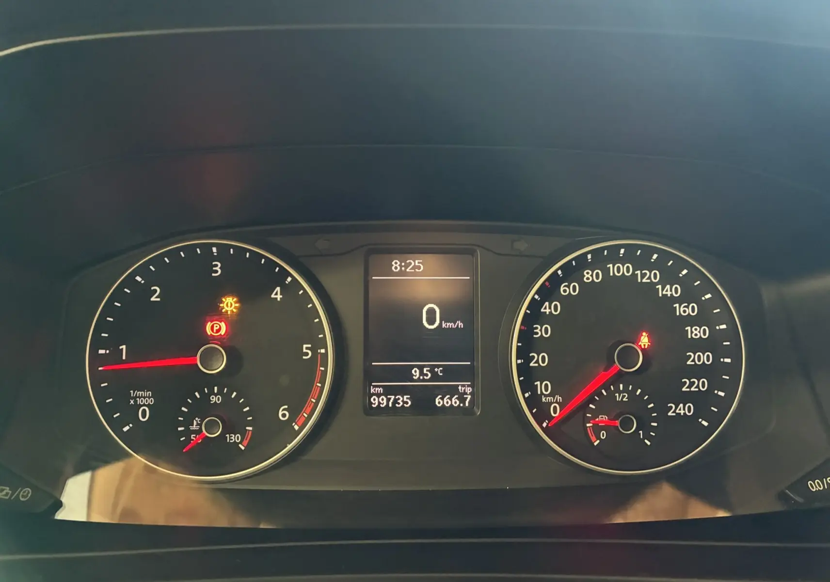 Vue rapprochée du tableau de bord du Volkswagen Multivan noir, affichant les compteurs et l'écran digital central.