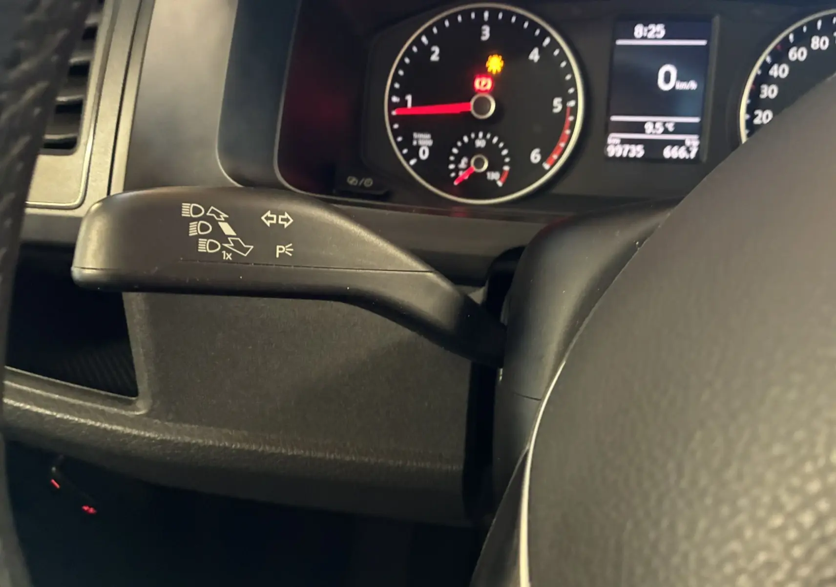 Gros plan sur le commodo gauche du tableau de bord du Volkswagen Multivan T6 noir, avec compteurs et voyants allumés.