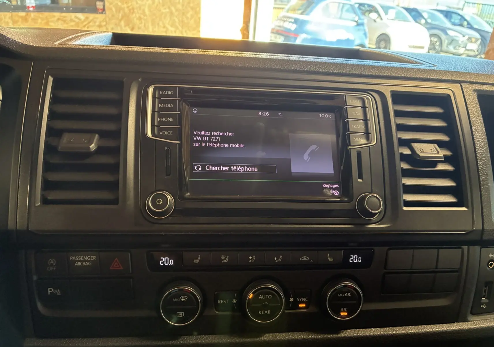 Vue rapprochée du tableau de bord noir du Volkswagen Multivan T6 PH.1 avec écran tactile et commandes de climatisation.