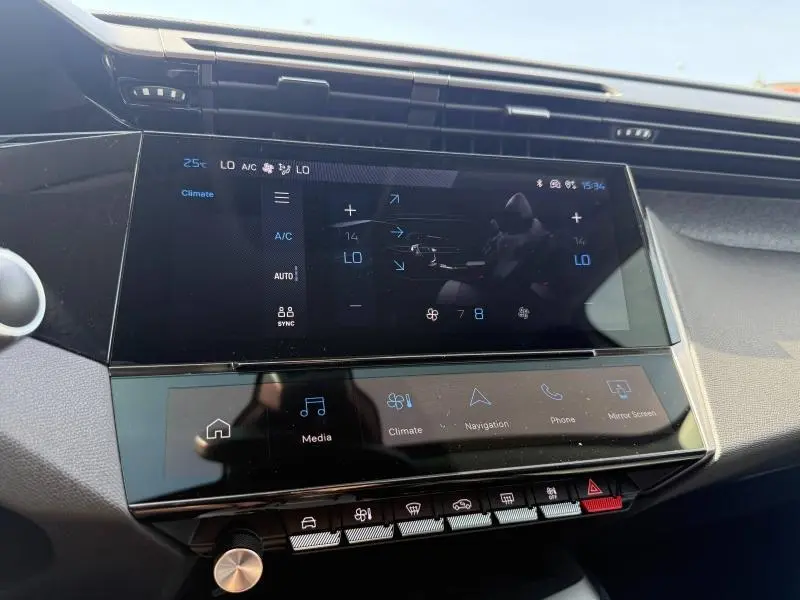Vue rapprochée de l’écran tactile central du tableau de bord de la Peugeot 308 Hybrid 2025, affichant les commandes climatiques.