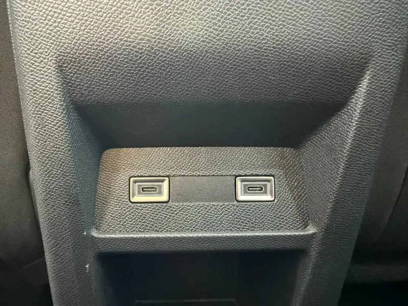 Vue rapprochée de deux ports USB-C intégrés dans la console arrière d'une Peugeot 308 1.2 Hybrid blanche.