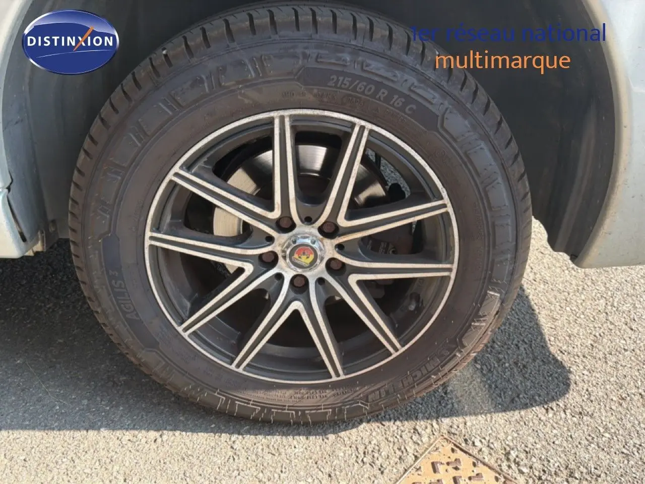Gros plan sur la roue avant gauche du FIAT Scudo Fourgon gris métal, avec jante alliage noire à motifs argentés.