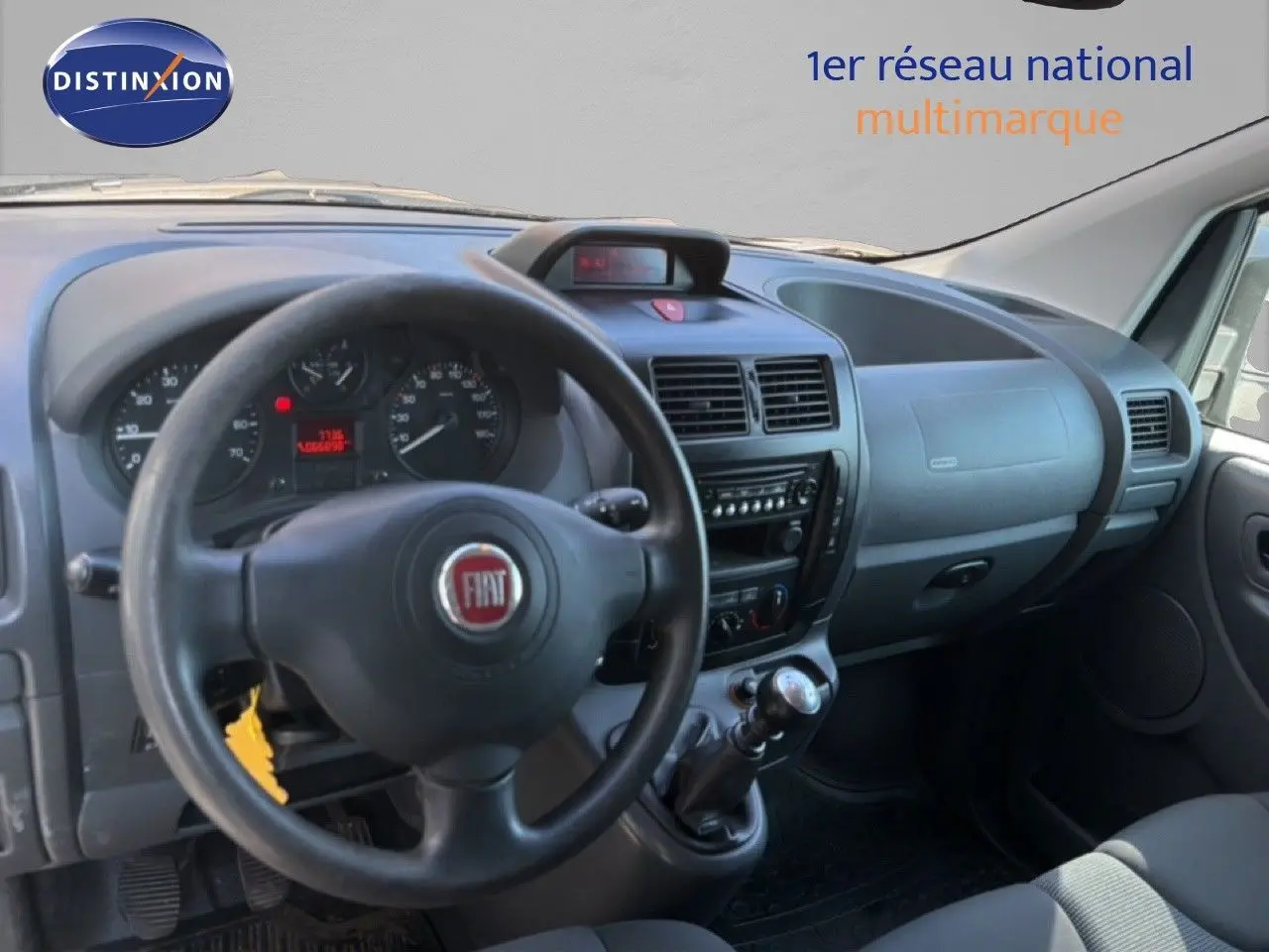 Vue intérieure côté conducteur du tableau de bord et volant noir du Fiat Scudo Fourgon gris métal de 2016.