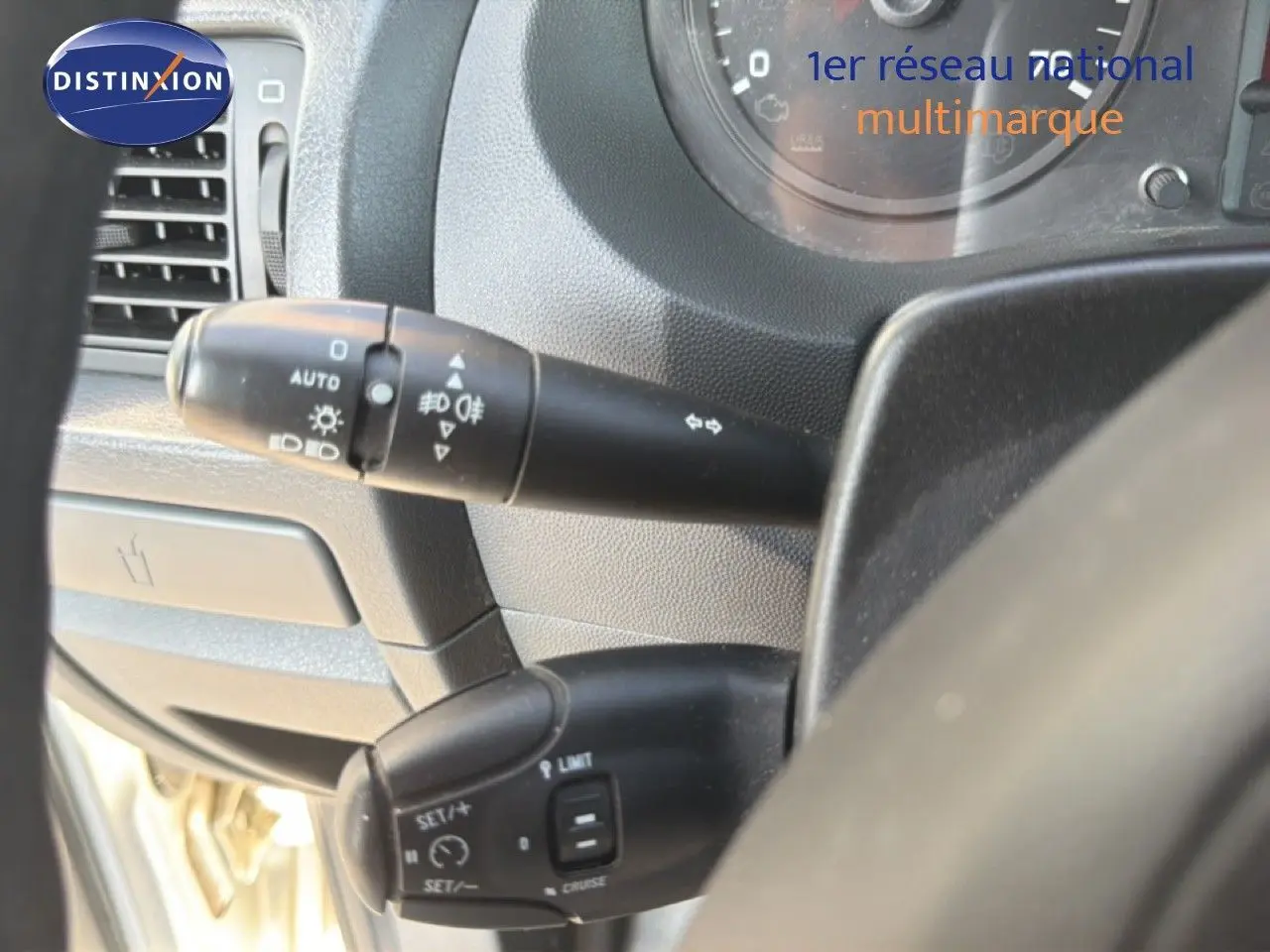 Gros plan sur les commandes de clignotants et régulateur de vitesse du tableau de bord du Fiat Scudo Fourgon gris métal.