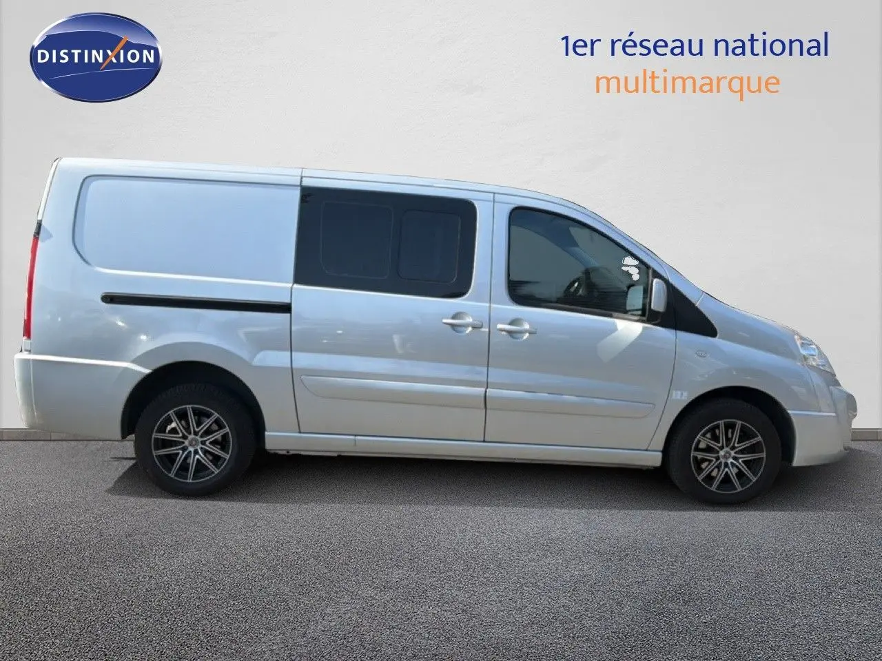 Vue de profil côté droit d’un FIAT Scudo Fourgon gris métal avec jantes alliage et vitres arrière teintées.
