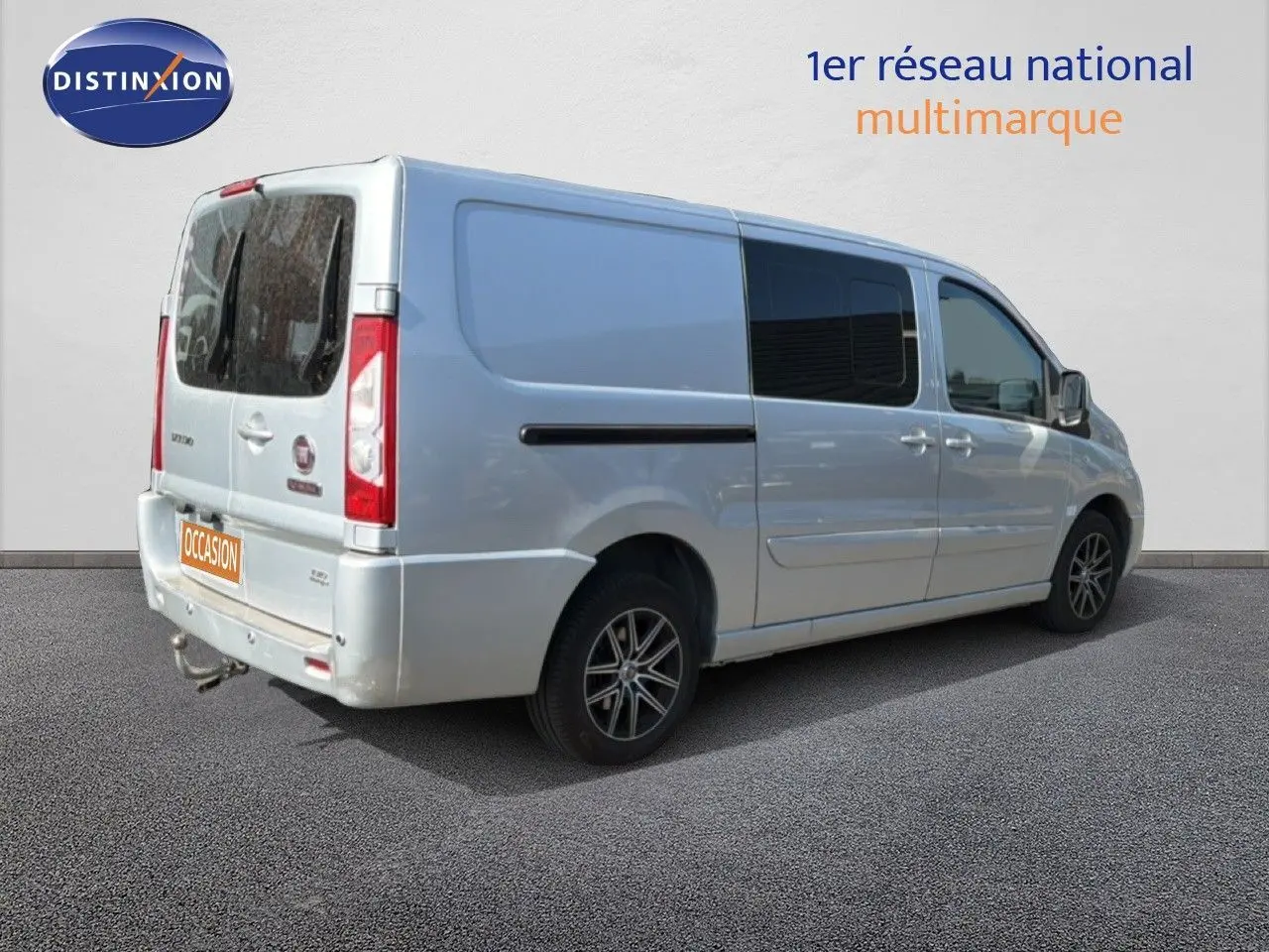 Vue 3/4 arrière droite d'un FIAT Scudo Fourgon gris métal avec vitres teintées et jantes alliage noires.