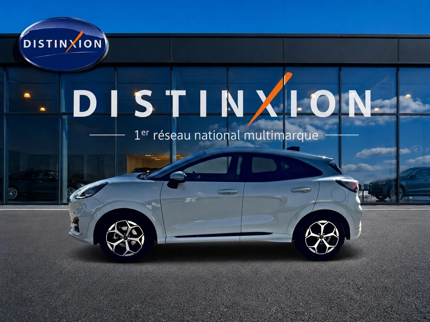 Ford Puma gris cactus vue de profil droit devant une vitrine avec logo Distinxion, jantes alu et vitres surteintées.
