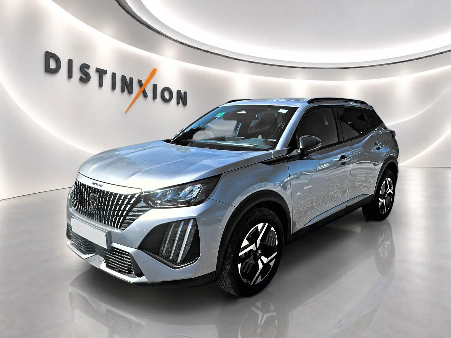Peugeot 2008 gris Artense vue 3/4 avant droit, avec calandre distinctive et jantes alu noires et argentées.