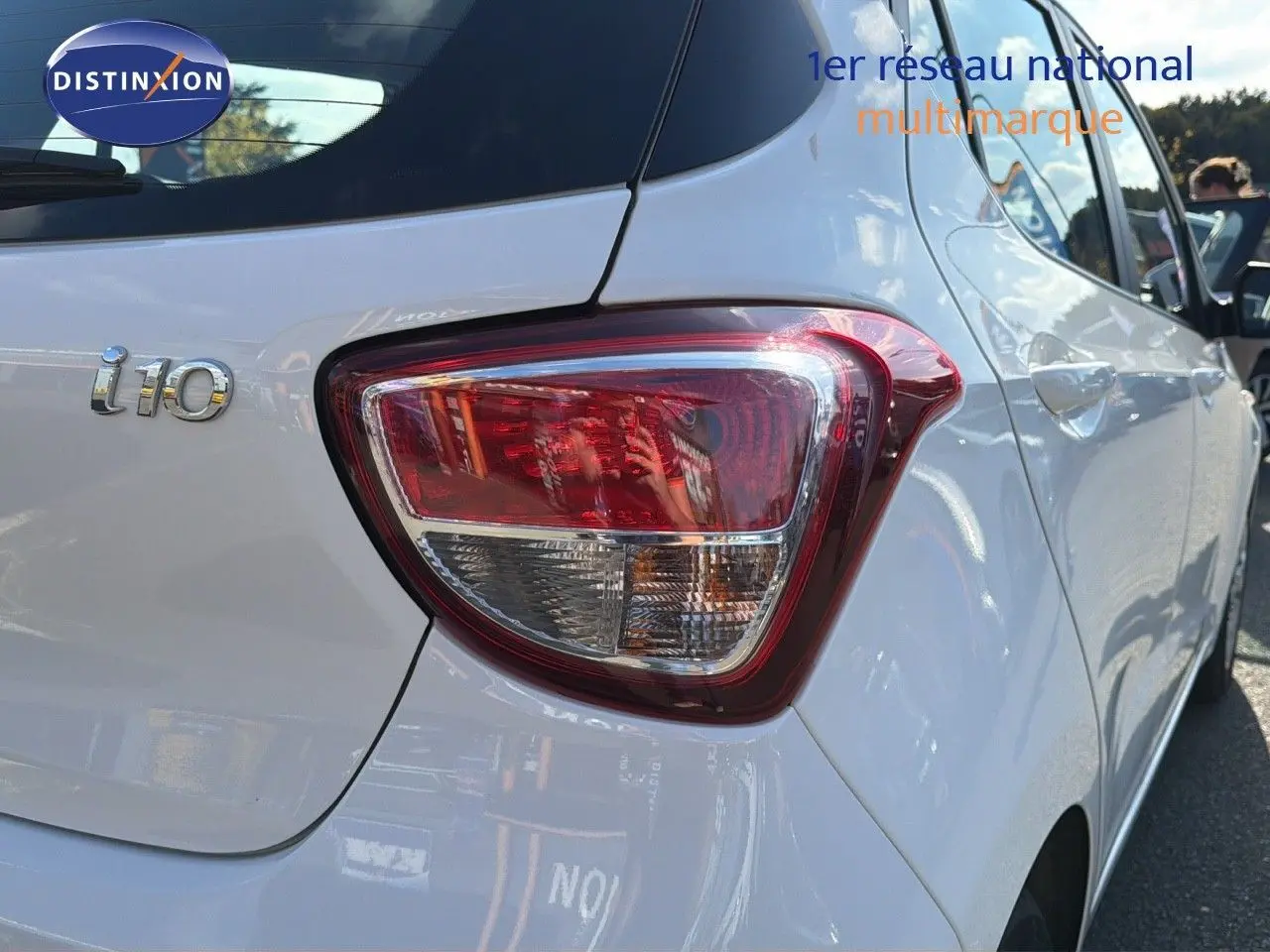 Feu arrière droit et logo i10 sur une Hyundai i10 blanche vue de l'arrière côté droit.