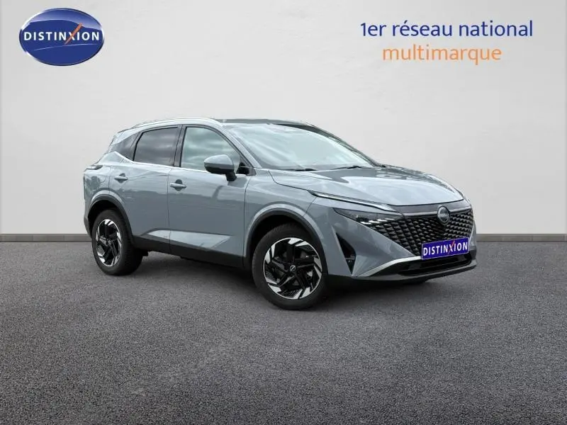 Vue 3/4 avant droit du Nissan Qashqai 2025 gris Argile avec calandre noire et jantes alliage noires.