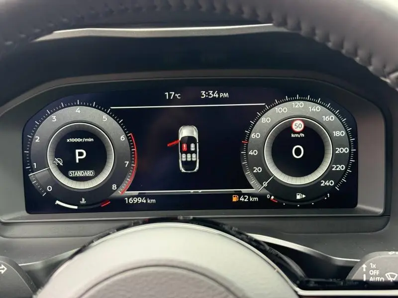 Tableau de bord numérique du Nissan Qashqai 2025 affichant la vitesse, le régime moteur et l'état des portes ouvertes.