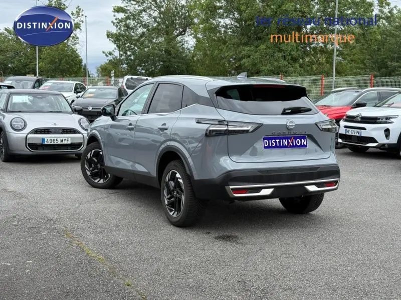 Vue 3/4 arrière droite d'un Nissan Qashqai 2025 gris Argile avec jantes noires et feux arrière LED distinctifs.