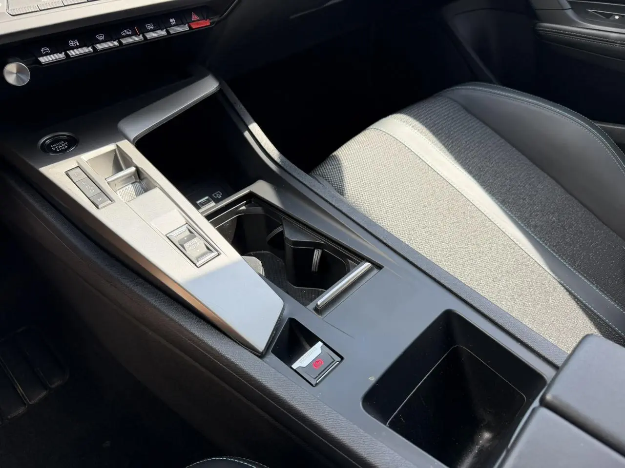 Vue rapprochée de la console centrale et siège avant gris clair avec surpiqûres sur la Peugeot 308 2025.
