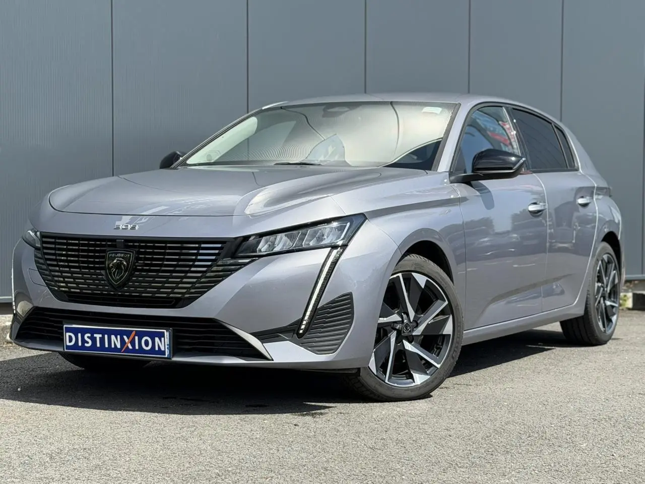 Peugeot 308 gris Artense vue 3/4 avant avec calandre noire brillante et jantes alliage 17 pouces Halong.