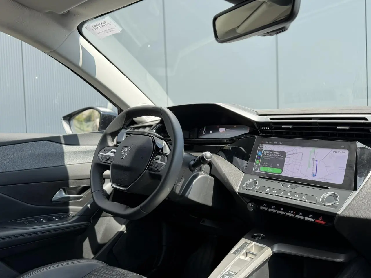 Vue intérieure côté conducteur du Peugeot 308 2025 avec tableau de bord numérique et écran tactile central.