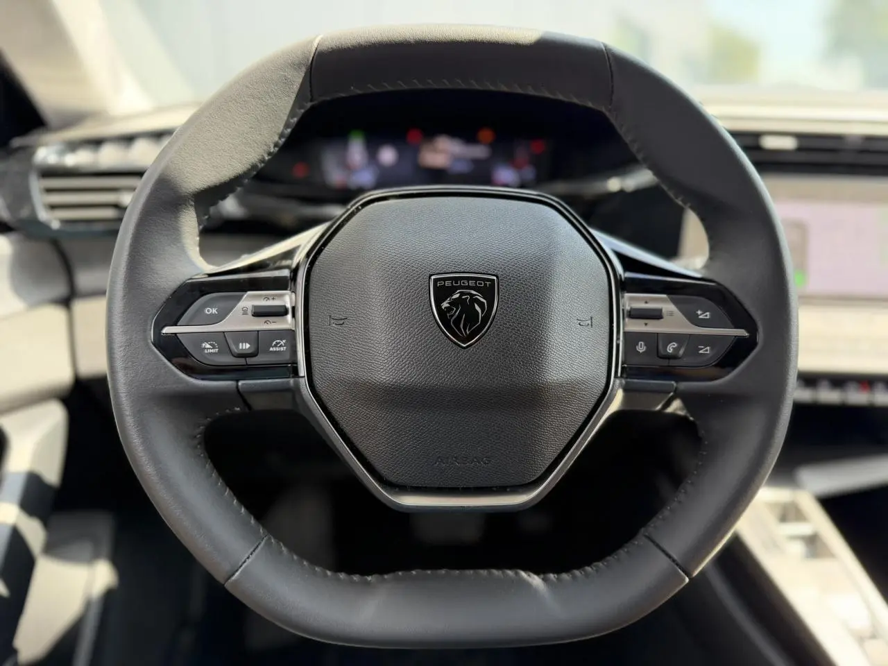 Volant en cuir noir de Peugeot 308 2025 vu de face, avec commandes intégrées et logo lion central.