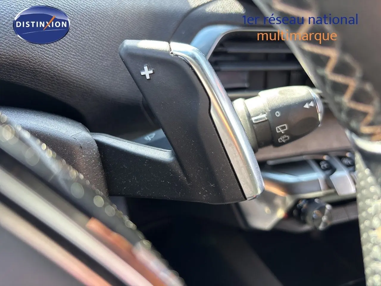 Gros plan sur la palette de changement de vitesse droite en aluminium et plastique noir dans l’habitacle du Peugeot 5008 blanc nacré.