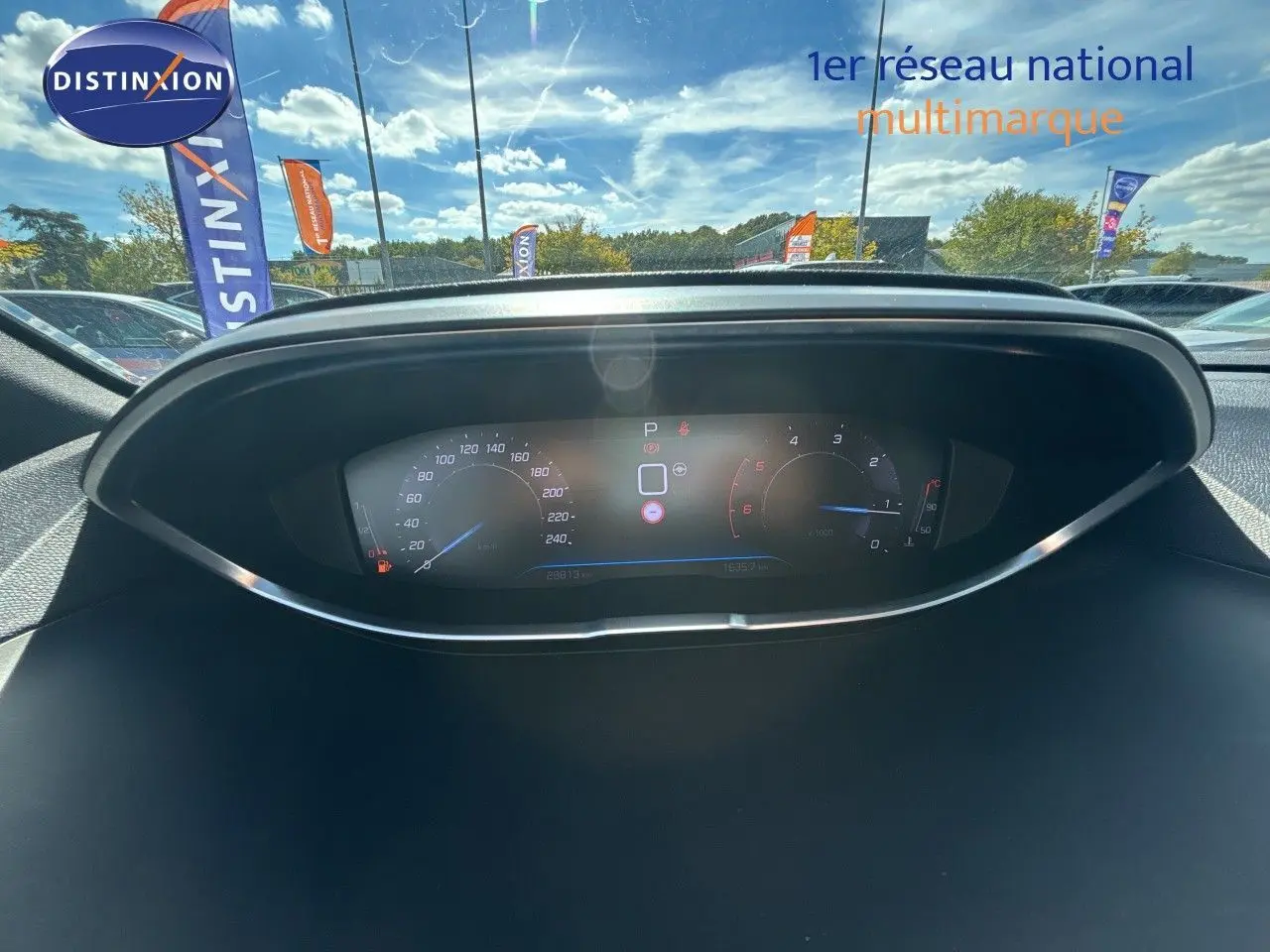Vue rapprochée du tableau de bord numérique du Peugeot 5008 blanc nacré, affichant vitesse et compte-tours.