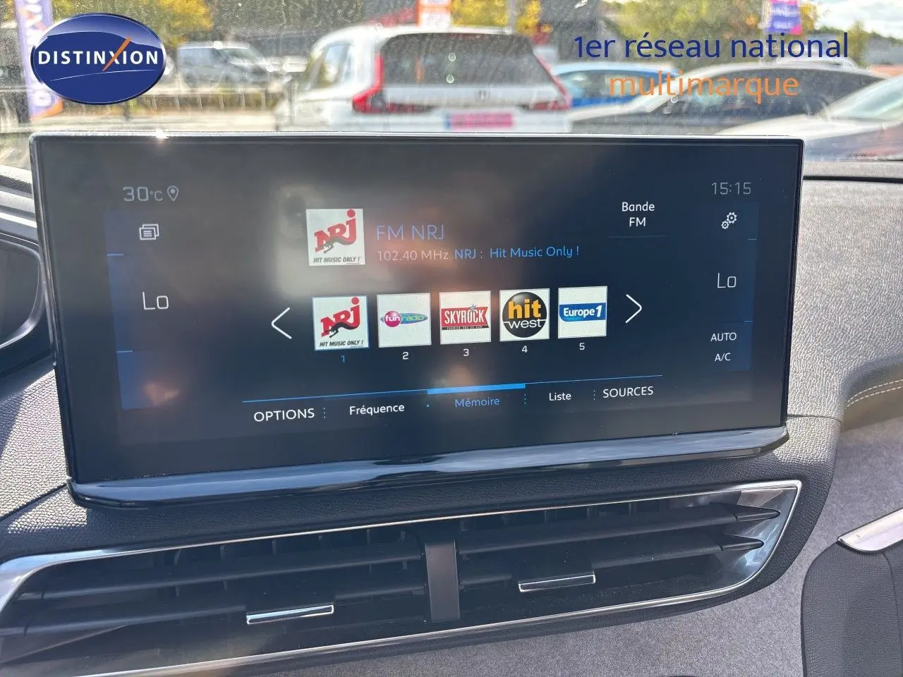 Écran tactile central du Peugeot 5008 GT 2023 montrant les stations radio, avec tableau de bord et aérateurs visibles.