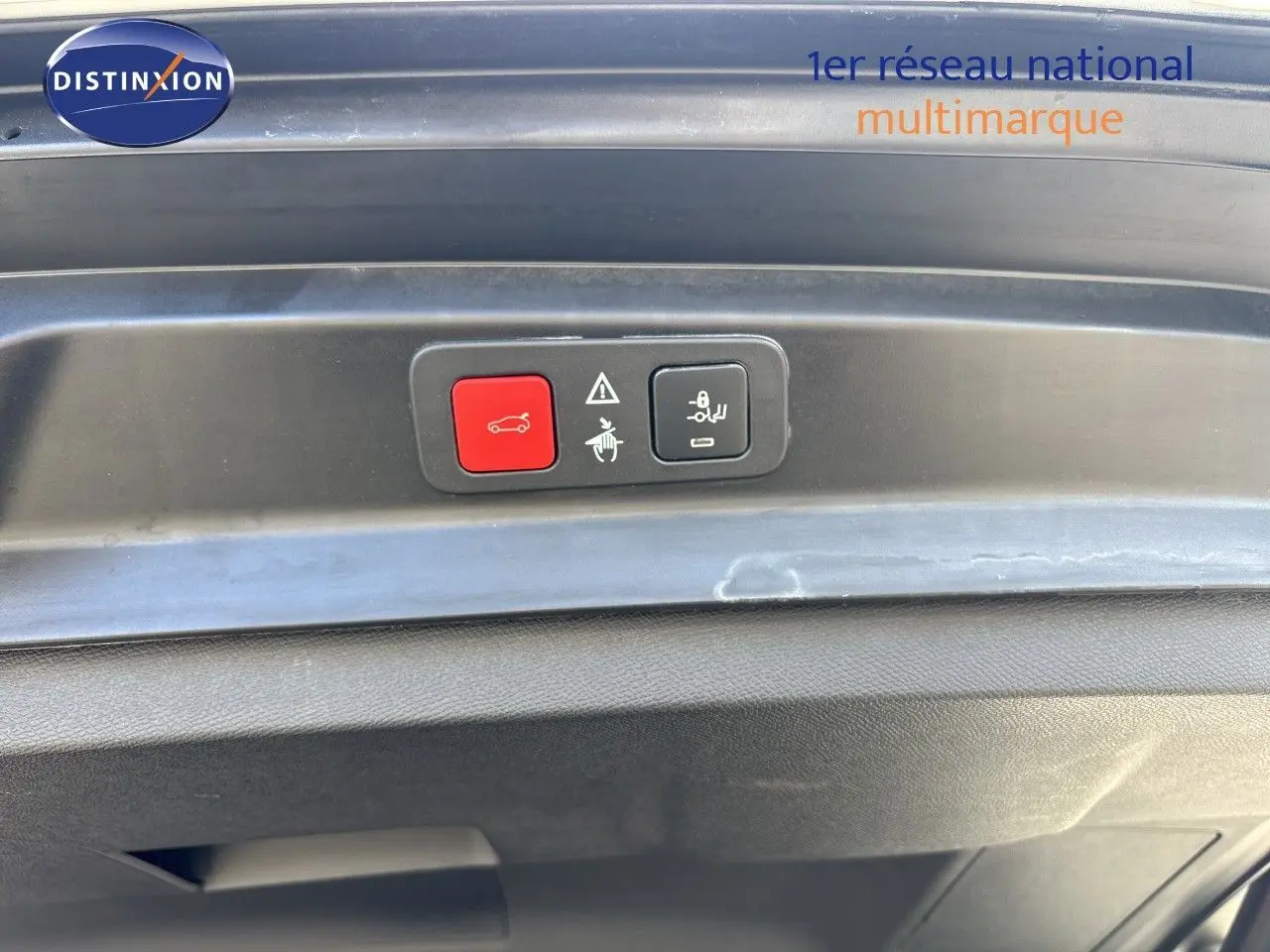 Boutons de commande du hayon électrique sur la partie intérieure du coffre d’un Peugeot 5008 blanc nacré, vue rapprochée.