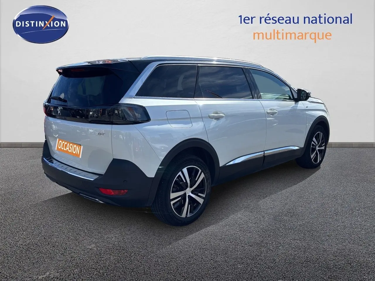 Peugeot 5008 BlueHDi 130 GT blanc nacré vu en 3/4 arrière droit, avec vitres teintées et jantes alliage bicolores.