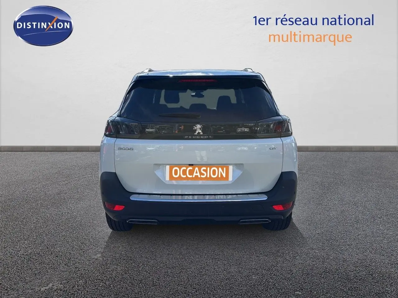 Vue arrière d’un Peugeot 5008 blanc nacré 2023 avec feux arrière noirs et double sortie d’échappement.