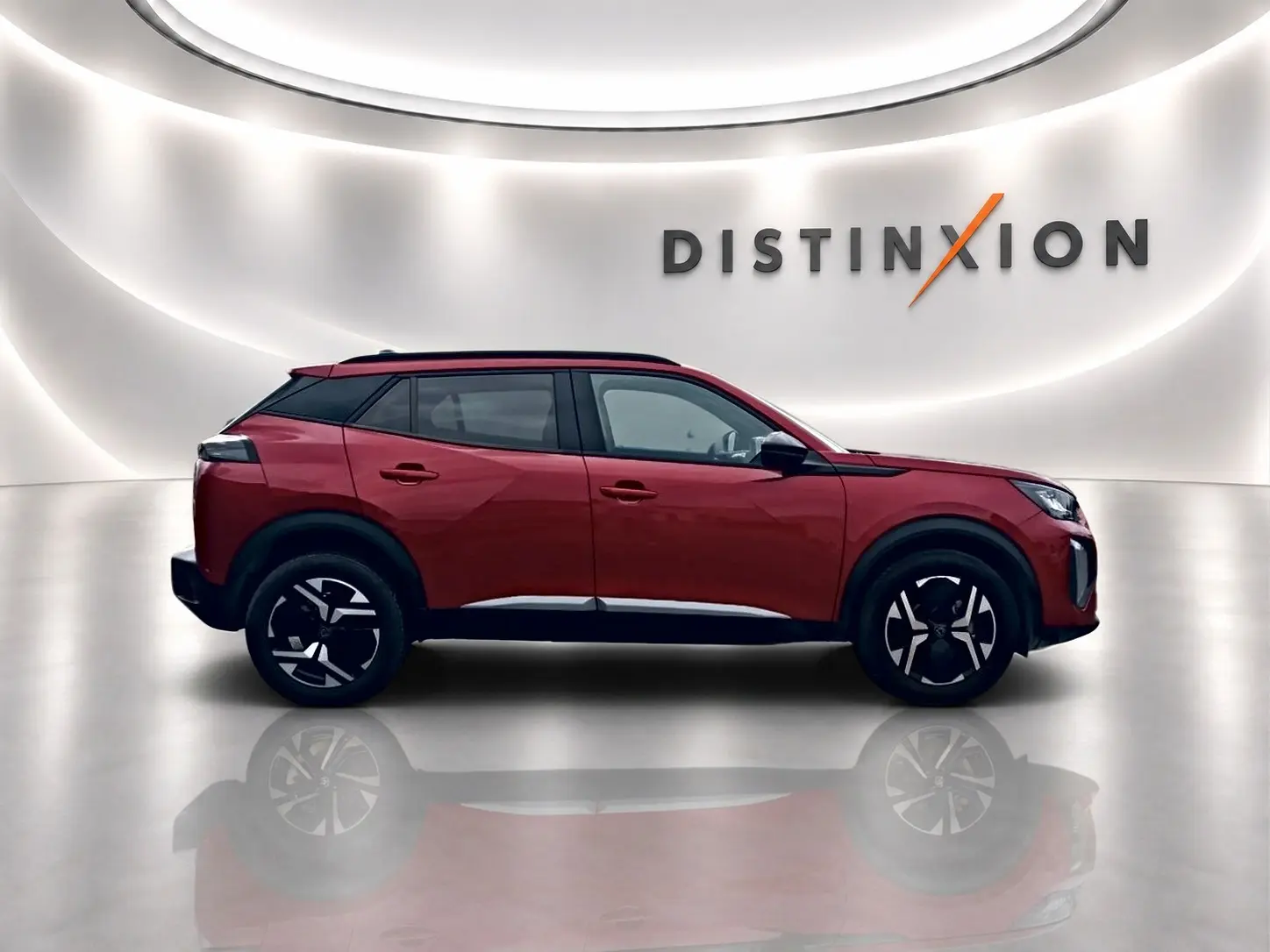 Profil droit du Peugeot 2008 1.2 100 Allure rouge elixir avec jantes alu et toit noir dans un studio lumineux.
