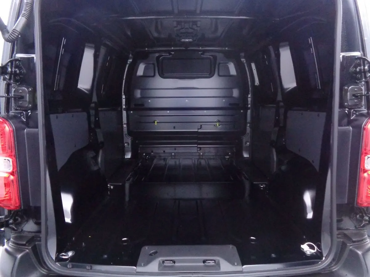 Vue intérieure arrière du fourgon Peugeot Expert Standard 2022 noir métal, montrant l'espace de chargement vide et les portes ouvertes.