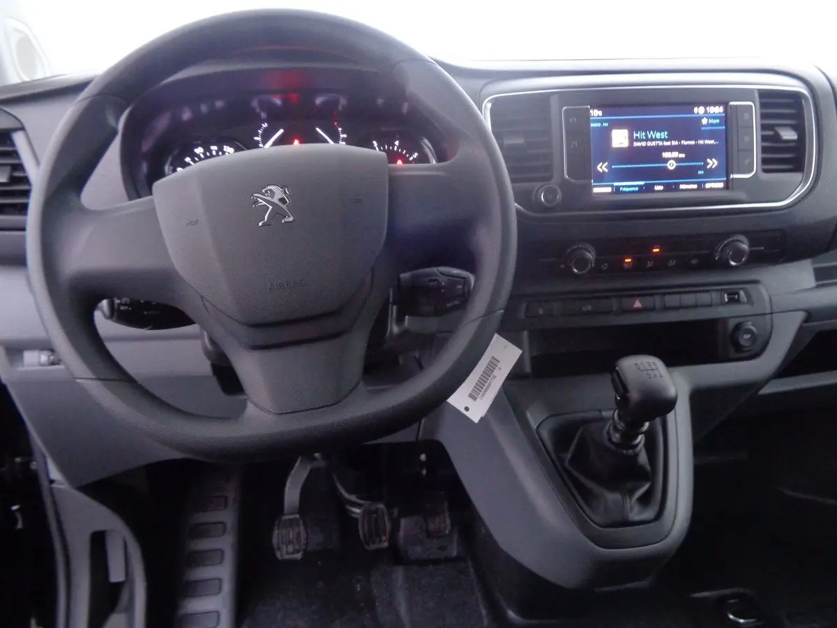 Vue intérieure du tableau de bord et volant Peugeot Expert Fourgon noir, avec levier de vitesse manuel et écran tactile.