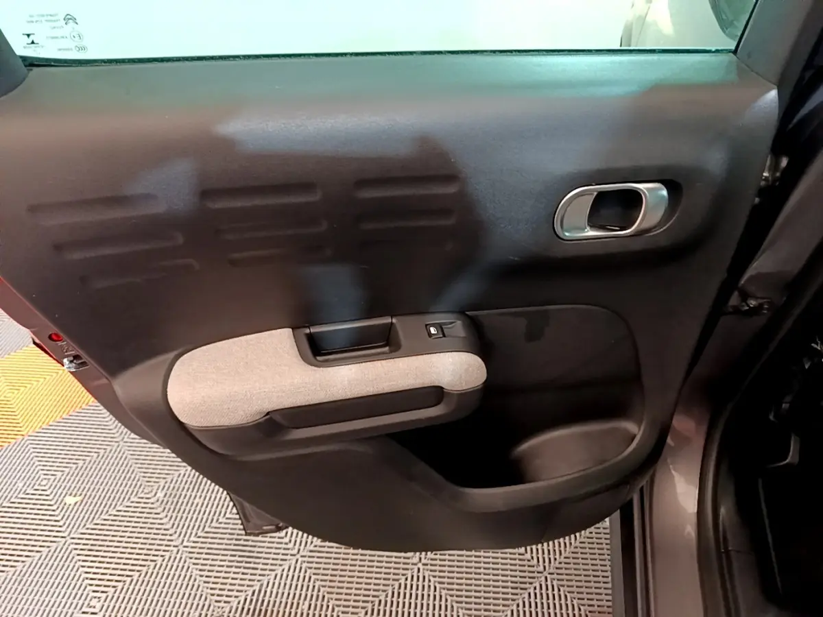Vue rapprochée de la porte arrière droite noire avec accoudoir gris clair du Citroën C3 Aircross 2020.