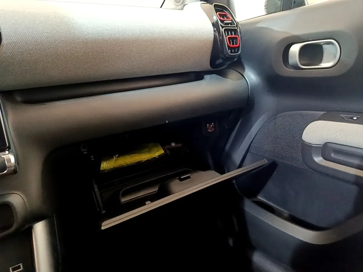 Intérieur du Citroën C3 Aircross 2020, vue côté passager sur la boîte à gants ouverte avec détails gris et noirs.