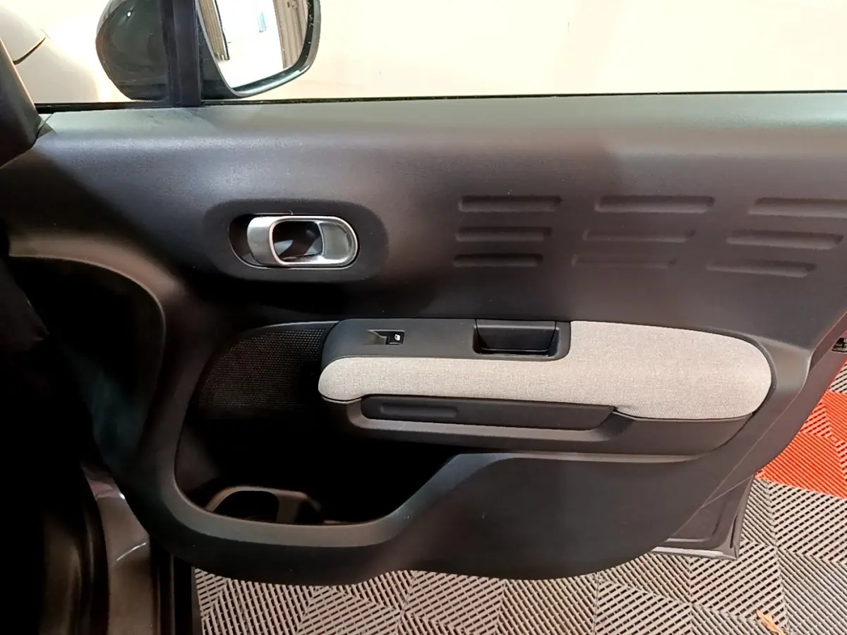 Gros plan sur la porte côté gauche du Citroën C3 Aircross 2020, avec insert textile gris clair et poignée chromée.