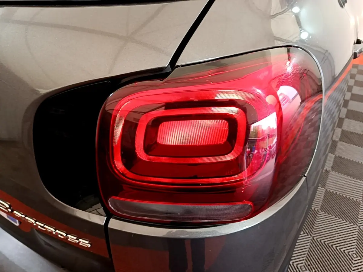Gros plan sur le feu arrière droit rouge d'un Citroën C3 Aircross gris 2020, avec logo partiel visible sur le coffre.