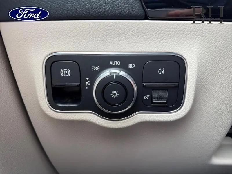 Panneau de commande des phares et feux, intérieur beige clair, avec molette centrale et boutons noirs.